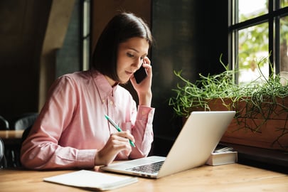 concentrated-brunette-woman-sitting-by-table-with-laptop-computer