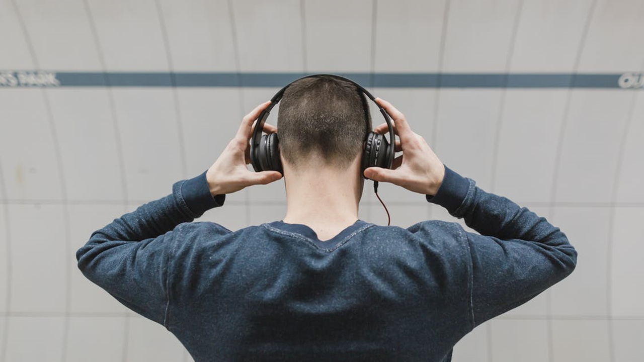 hombre con audífinos escuchando podcast